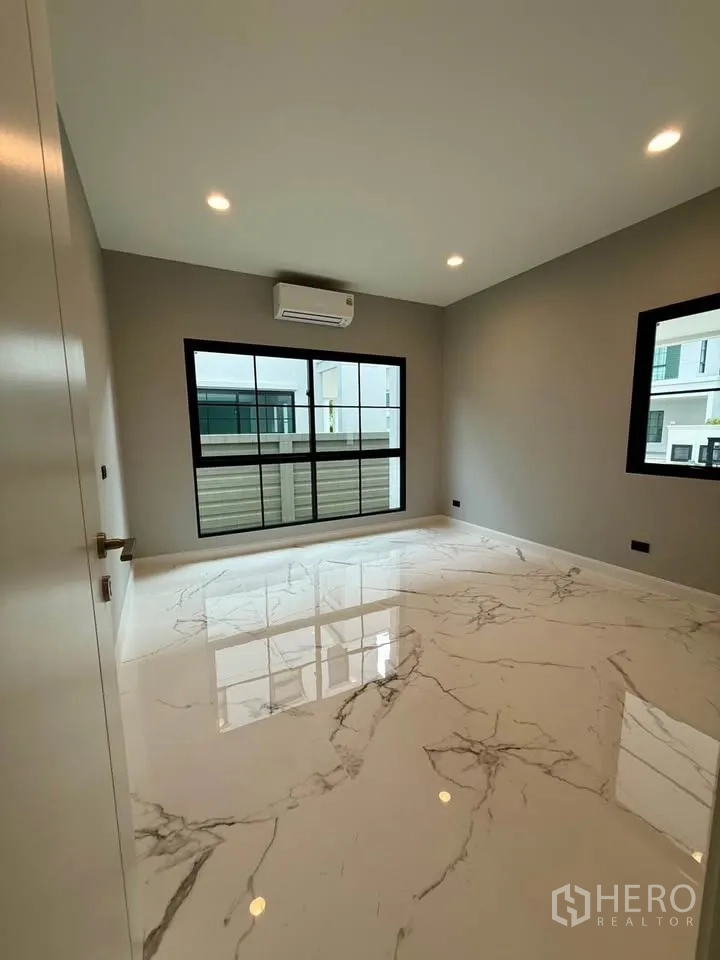 Detached House for rent in Don Mueang, Bangkok - Bright room with glossy marble-look floor and air conditioner.