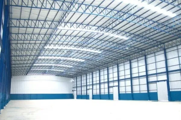 Warehouse for rent in Pathum Thani - Bright warehouse interior with high-clear steel truss roof, skylight panels and a clear-span floor.