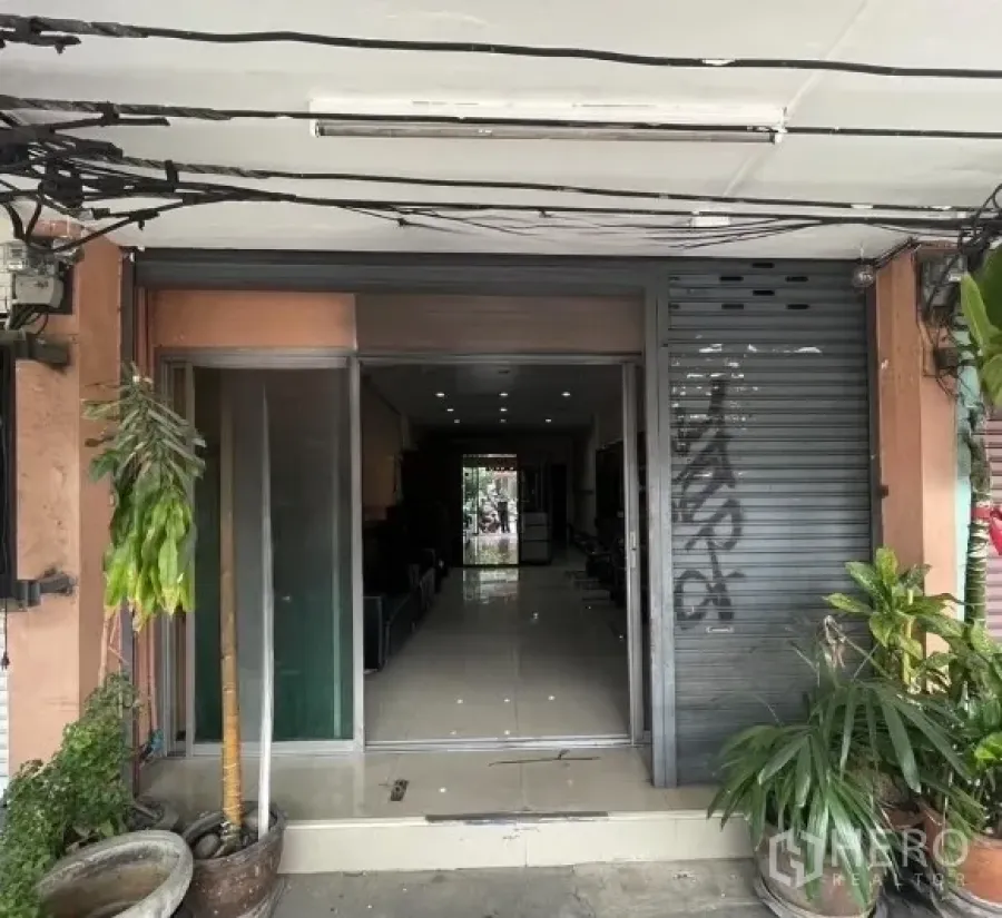 店屋 出租在Phra Khanong, Bangkok - 商铺入口，金属卷闸半开，配玻璃门。