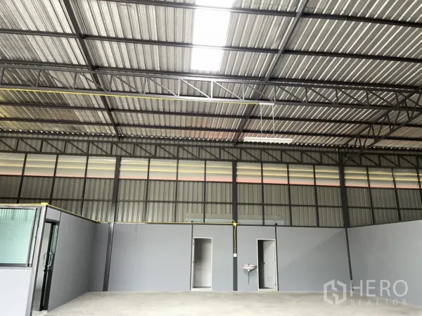 工厂 出租在Khlong Luang, Pathum Thani - 高挑梁架与透光板，上方照明充足，下方设两间卫生间与洗手盆。