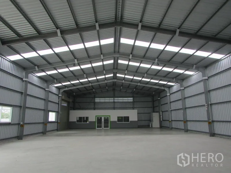 Warehouse for rent in Pak Kret, Nonthaburi - Spacious warehouse interior with high gabled roof, skylights and an internal office block.