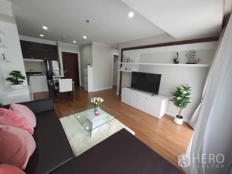 อพาร์ทเมนท์ ให้เช่าในWatthana, Bangkok - ห้องนั่งเล่นแบบโอเพ่นแปลน โซฟาเข้ามุม โต๊ะกลางกระจก ชั้นวางทีวี และพื้นไม้