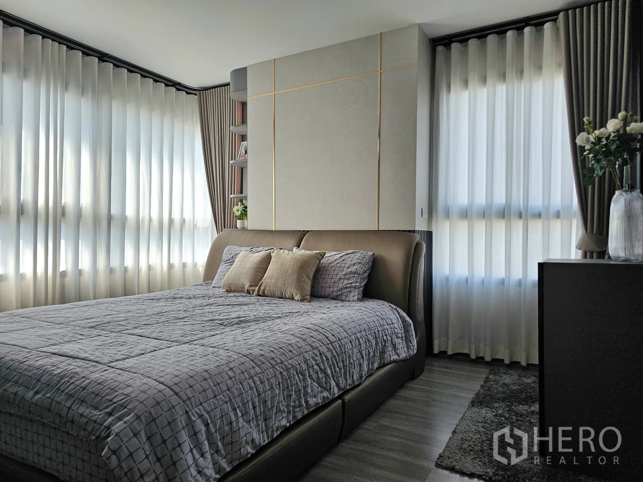 คอนโด for sale in Bang Rak, Bangkok - ห้องนอนสว่างพร้อมเตียงหุ้มหนัง ผ้าม่านโปร่ง และตู้ข้างเตียงพร้อมแจกันดอกไม้