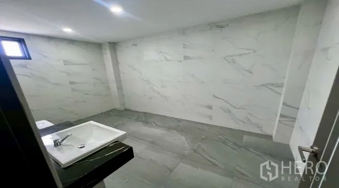 Warehouse for rent in Bang Bo, Samut Prakan - Restroom with tiled walls, a window, and a countertop basin.