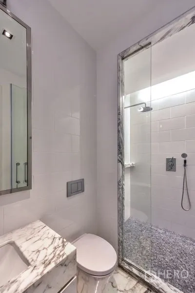 公寓 出租在Bang Rak, Bangkok - 紧凑的客卫，带大理石洗手台、马桶和玻璃淋浴间。