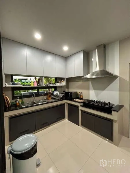 Detached House for rent in Bang Kapi, Bangkok - Kitchen from another angle showing double sink, upper cabinets and window backsplash.