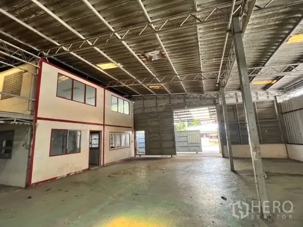 Warehouse for rent in Suan Luang, Bangkok - Spacious warehouse bay with high steel truss roof, large sliding door, and internal two‑storey office.
