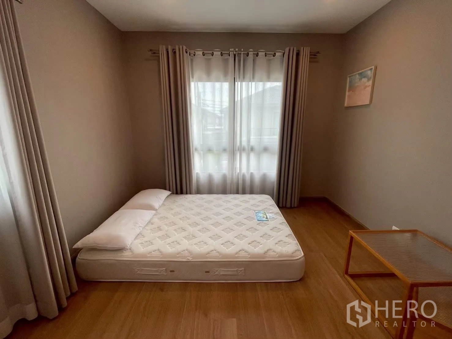 Detached House for rent in Bang Phli, Samut Prakan - Corner bedroom with a large window, mattress and a small side table.