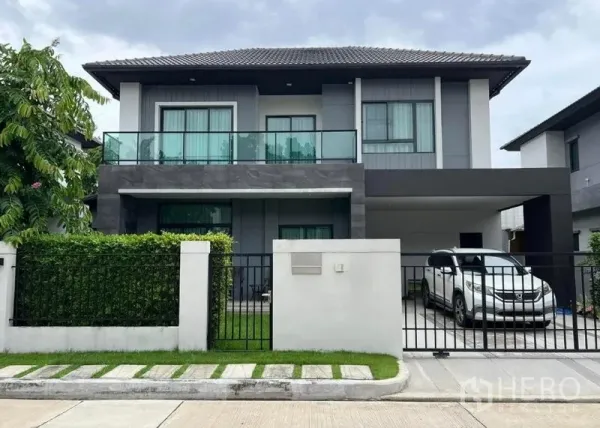 独立式住宅 出售在Khan Na Yao, Bangkok - 房屋正立面图：两层独栋别墅，带安全围栏与车棚。