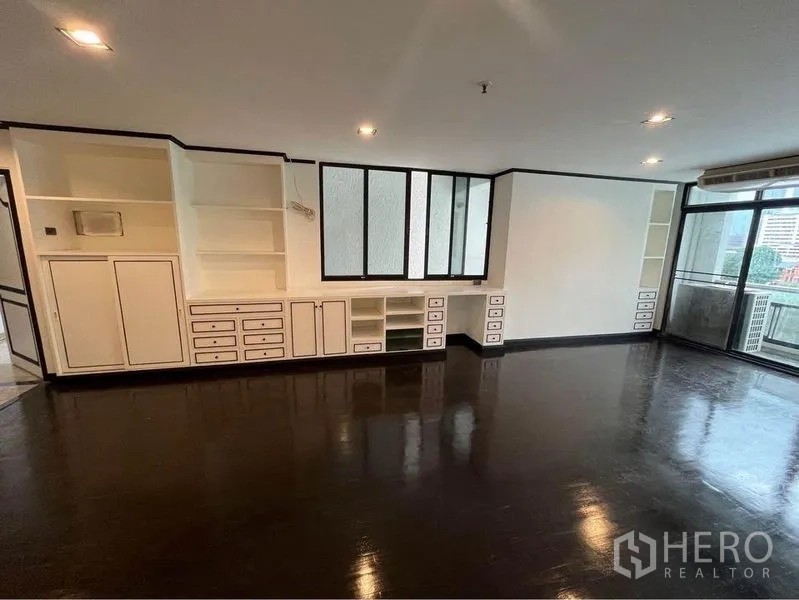 คอนโด ให้เช่าหรือขายในWatthana, Bangkok - ห้องนั่งเล่นกว้าง มีชั้นบิลต์อินเต็มผนัง และประตูกระจกออกระเบียง