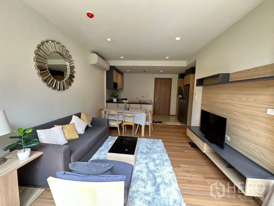 Condominium for rent in Watthana, Bangkok - Modern open-plan living and dining space with TV console and abundant natural light.
