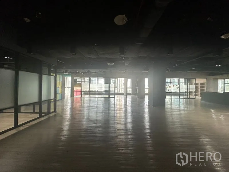 Office Space for rent in Bang Rak, Bangkok - Dimly lit panoramic view across the large office with windows at both ends.