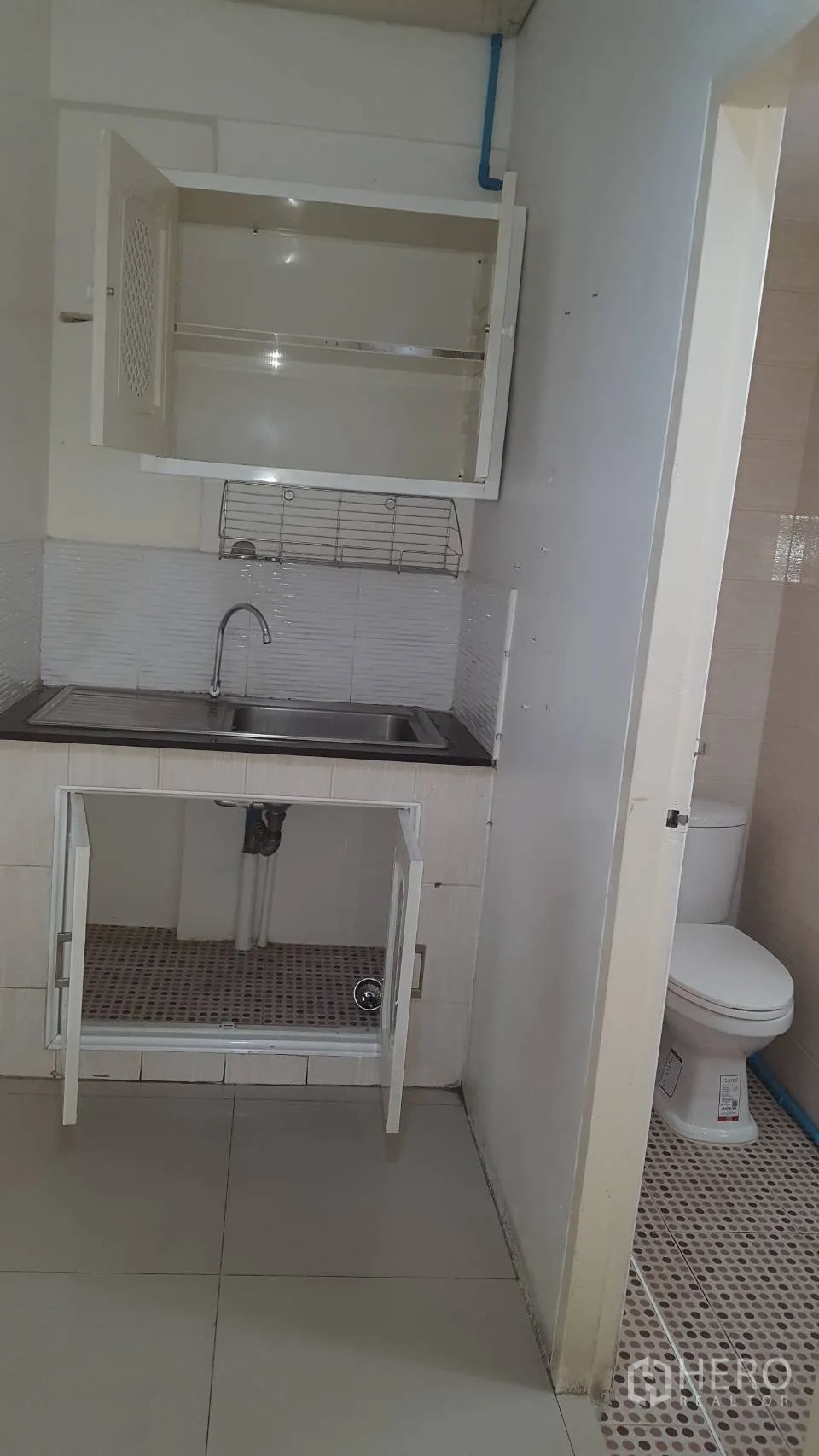 Office Space for rent in Khlong Toei, Bangkok - Compact pantry with sink, countertop and cabinetry next to the entrance to the bathroom.