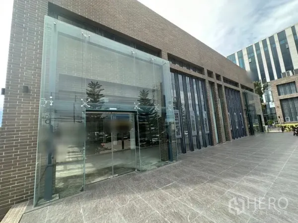 พื้นที่ขายปลีก ให้เช่าในBang Phli, Samut Prakan - ด้านหน้าตึกกับประตูกระจกสองชั้นและลานกระเบื้องกว้าง