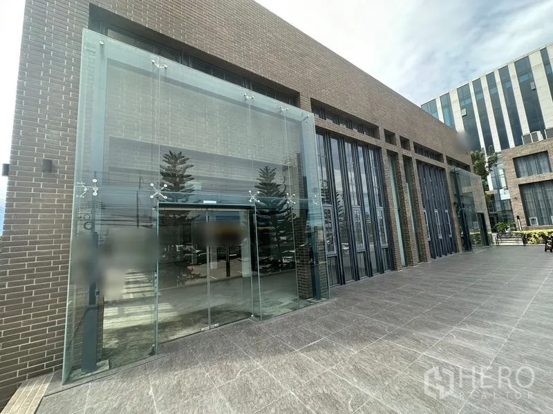 พื้นที่ขายปลีก ให้เช่าในBang Phli, Samut Prakan - ด้านหน้าตึกกับประตูกระจกสองชั้นและลานกระเบื้องกว้าง