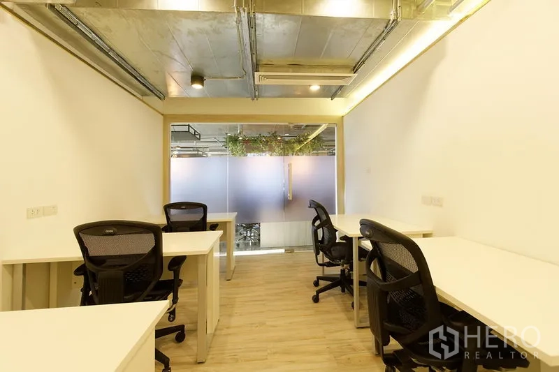 办公空间 出租在Watthana, Bangkok - 14㎡办公空间，人体工学椅，LED照明与裸露管道天花，磨砂玻璃门外可见绿植