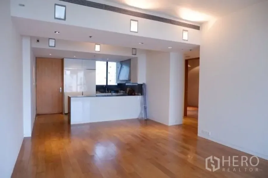 公寓 出售在Sathon, Bangkok - 开放式客厅，实木地板与简洁白色中岛厨房。