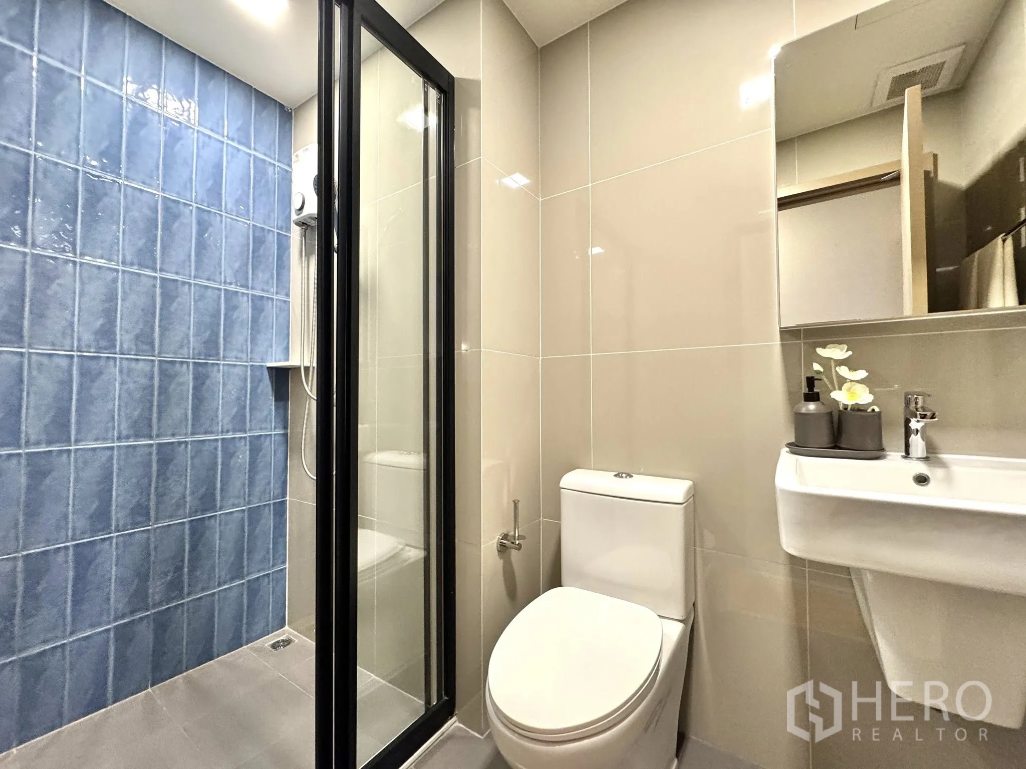 公寓 for rent in Watthana, Bangkok - 次卫设推拉玻璃淋浴门、蓝砖墙、坐便与镜柜。