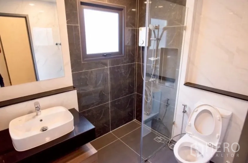 Detached House for rent in Bang Phli, Samut Prakan - Clean bathroom with glass shower and grey tiles.