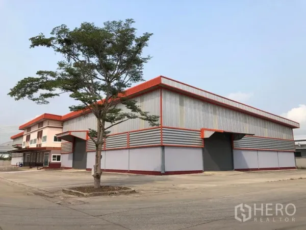 工厂 出租在Bang Len, Nakhon Pathom - 邦伦区现代钢结构工厂，红色装饰，宽阔混凝土车道与装卸区。