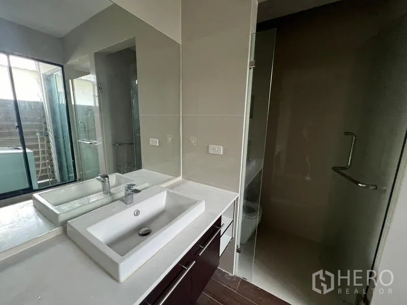 ทาวน์เฮาส์ ให้เช่าหรือขายในKhlong Toei, Bangkok - เคาน์เตอร์อ่างล้างหน้ากระจกบานใหญ่ข้างห้องอาบน้ำกระจกและหน้าต่าง