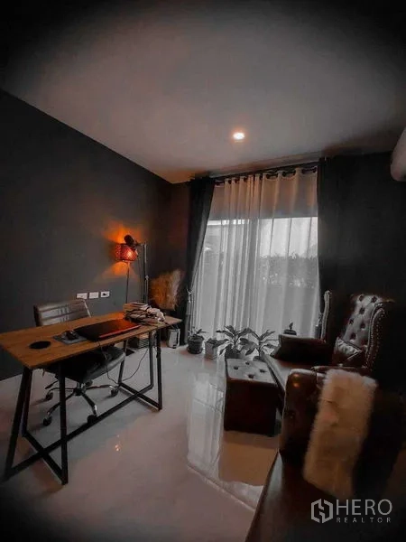 Detached House for rent in Bang Bo, Samut Prakan - Home office corner with desk, armchair and plants by glass doors.