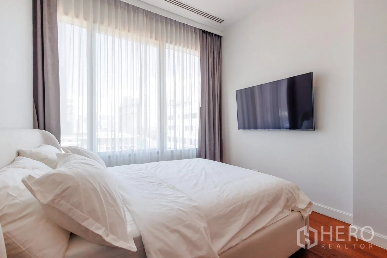 公寓 for rent or sale in Pathum Wan, Bangkok - 明亮卧室，落地窗配纱帘与壁挂电视。