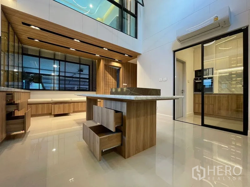 Townhouse for sale - Double‑height living and dining space with an island and sliding doors to a prep kitchen.