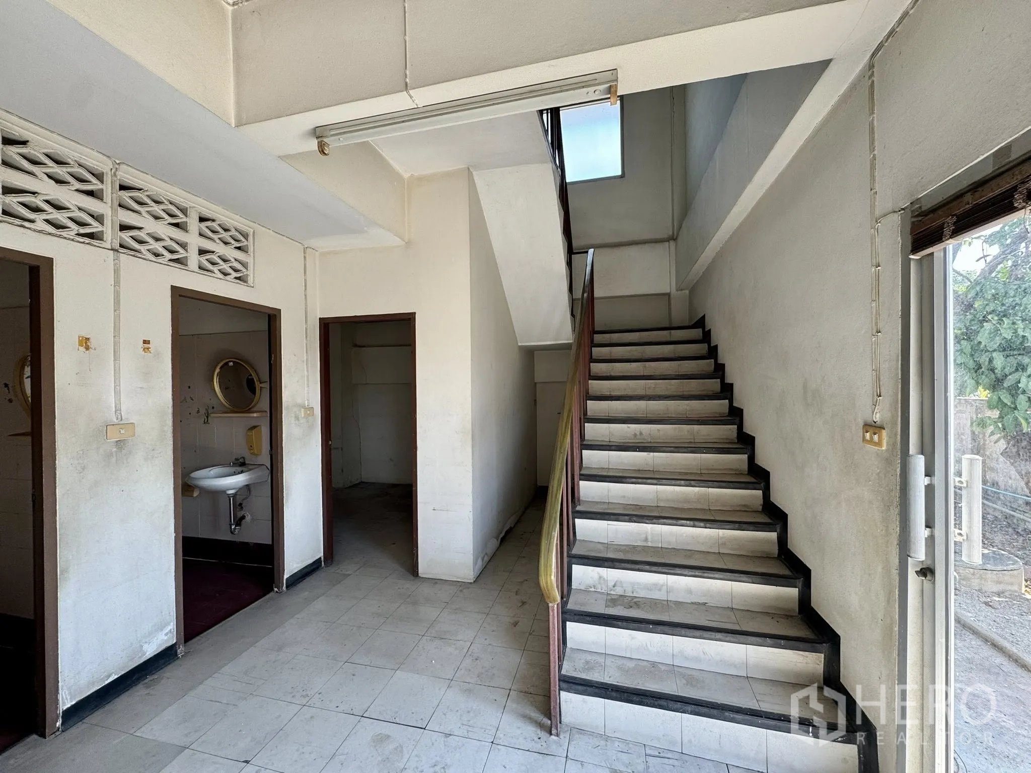 货栈 for rent in Mueang Samut Sakhon, Samut Sakhon - 入口大厅，楼梯与洗手间门，地面铺砖。