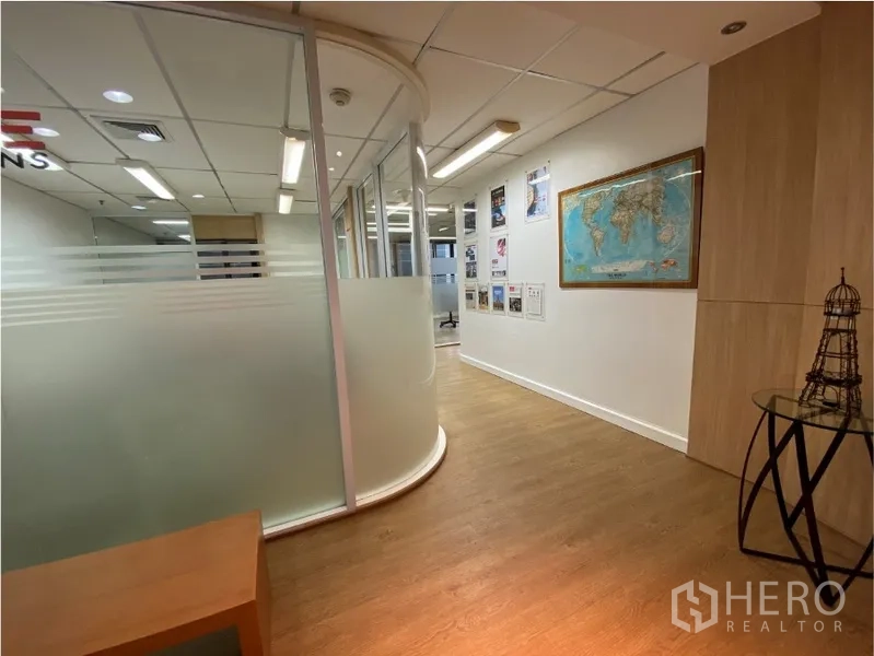 办公空间 出租在Khlong Toei, Bangkok - 走廊配弧形磨砂玻璃隔断会议室，木地板与墙面展示。