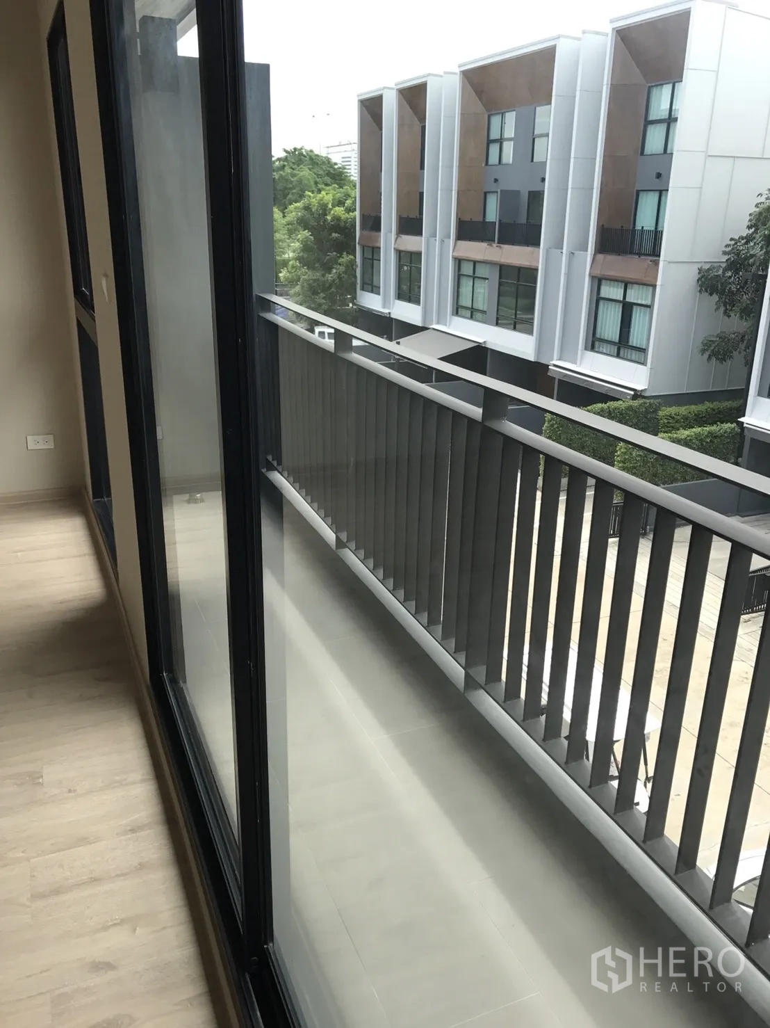 ทาวน์เฮาส์ ขายในSuan Luang, Bangkok - ระเบียงแคบติดประตูกระจก มองเห็นทาวน์เฮ้าส์สมัยใหม่และต้นไม้