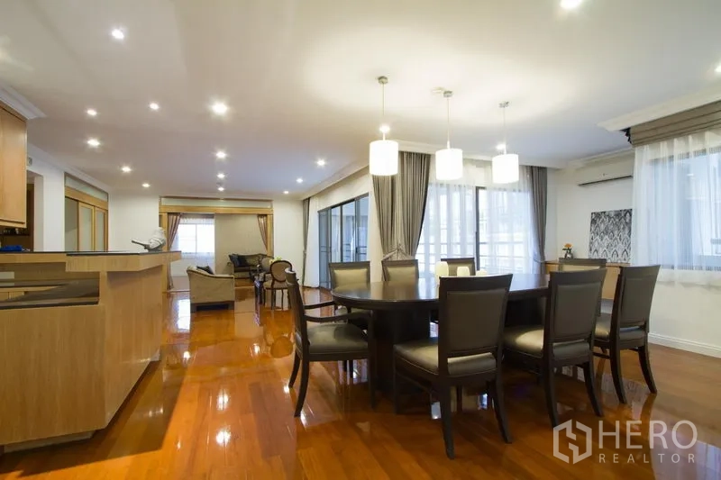 อพาร์ทเมนท์ ให้เช่าในWatthana, Bangkok - พื้นที่นั่งเล่นและรับประทานอาหารแบบโอเพนแปลน พร้อมโคมแขวน โต๊ะกลม และพื้นไม้เงางามติดหน้าต่างบานใหญ่