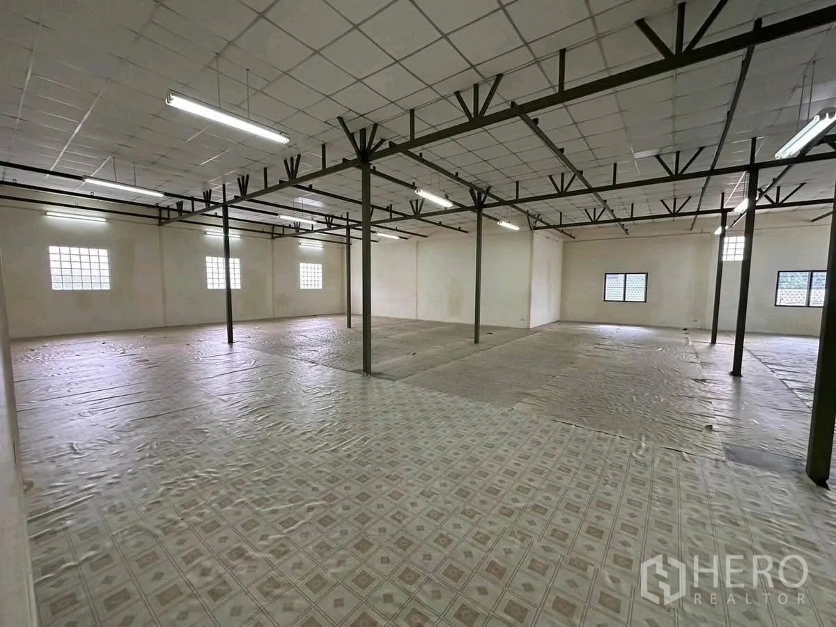 货栈 出租在Lat Phrao, Bangkok - 宽大仓储楼层，钢柱、网格天花与长条灯。