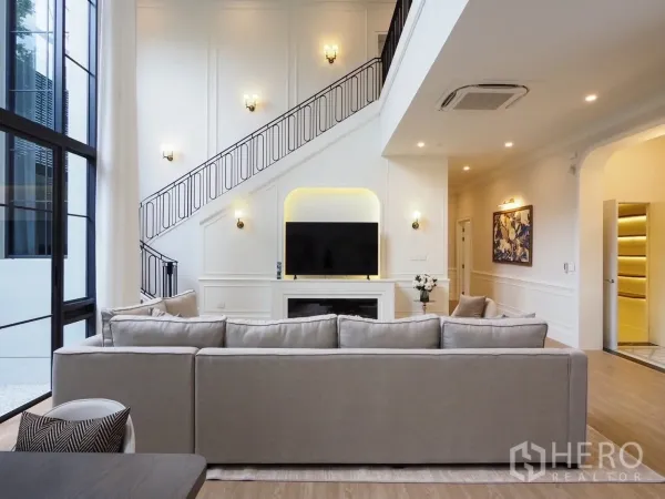 独立式住宅 出租在Bang Kapi, Bangkok - 开放式起居区，电视壁炉背景墙与锻铁栏杆