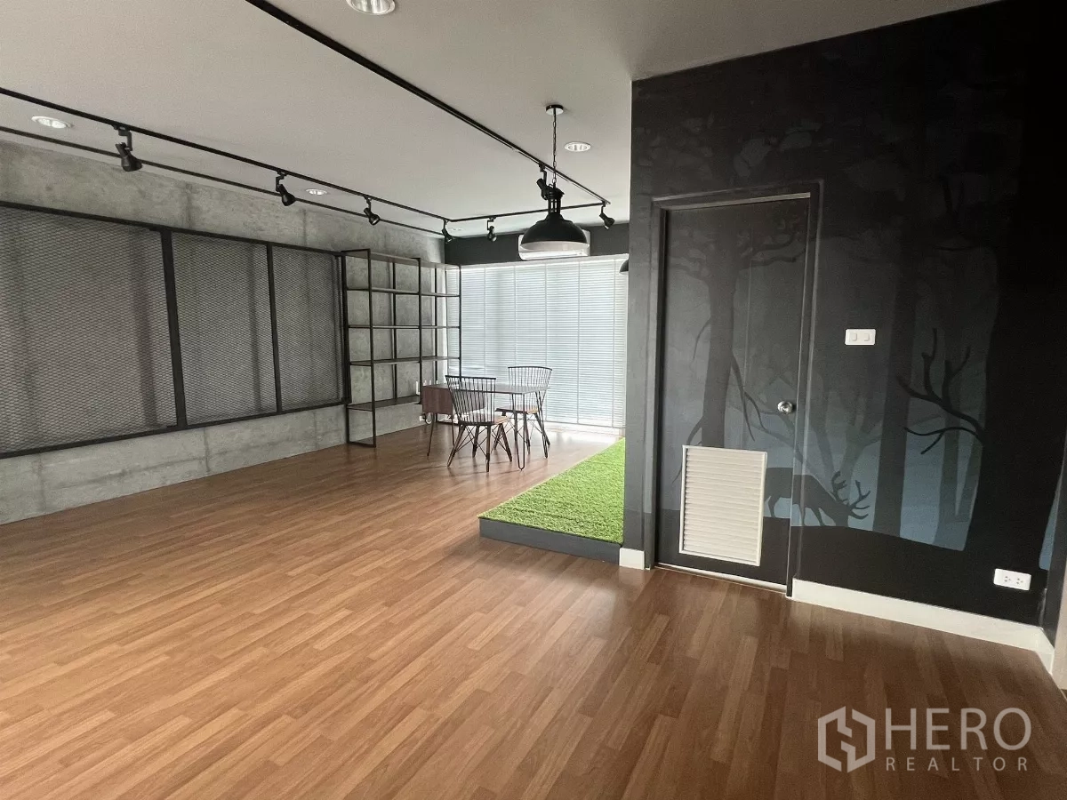 Detached House for rent or sale in Don Mueang, Bangkok - Studio area with forest mural, door and raised turf platform by window.