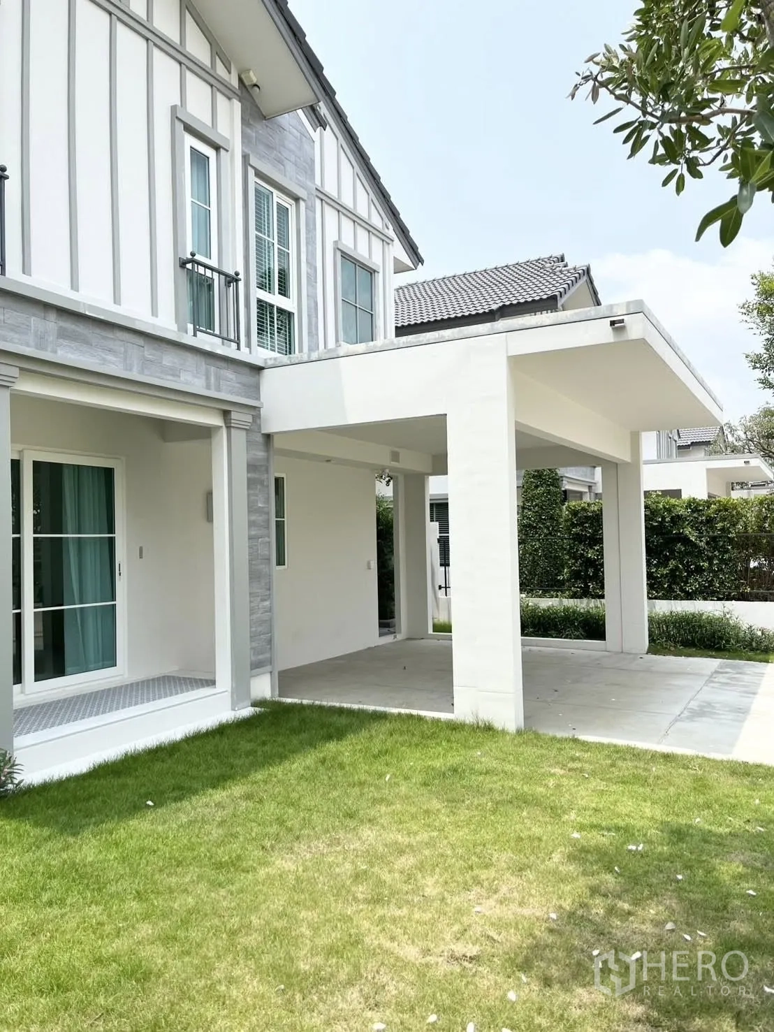 Detached House for rent in Bang Phli, Samut Prakan - Exterior view with green lawn, covered terrace, and side of the house.