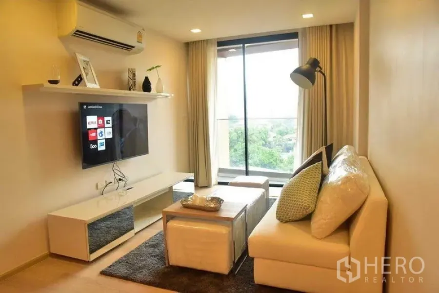 คอนโด ให้เช่าในWatthana, Bangkok - ห้องนั่งเล่นอบอุ่น โซฟา ชุดชั้นวางทีวี และหน้าต่างสูงมองเห็นวิวเขียว