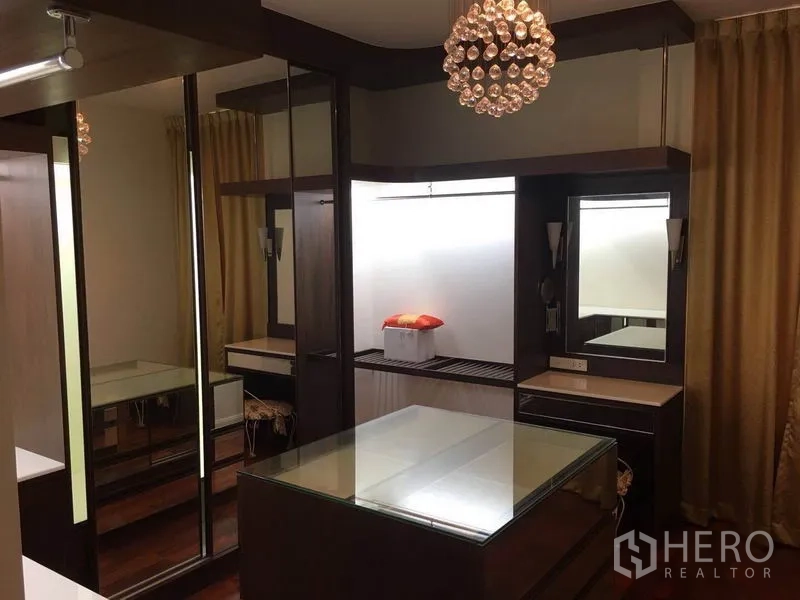 Detached House for rent in Bang Phli, Samut Prakan - Walk-in closet with mirrored wardrobes, dressing tables, and a decorative pendant chandelier.