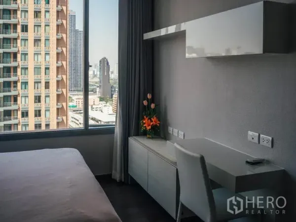 คอนโด ให้เช่าในRatchathewi, Bangkok - มุมทำงานในห้องนอน พร้อมโต๊ะและหน้าต่างบานใหญ่ชมวิวสกายไลน์กรุงเทพฯ