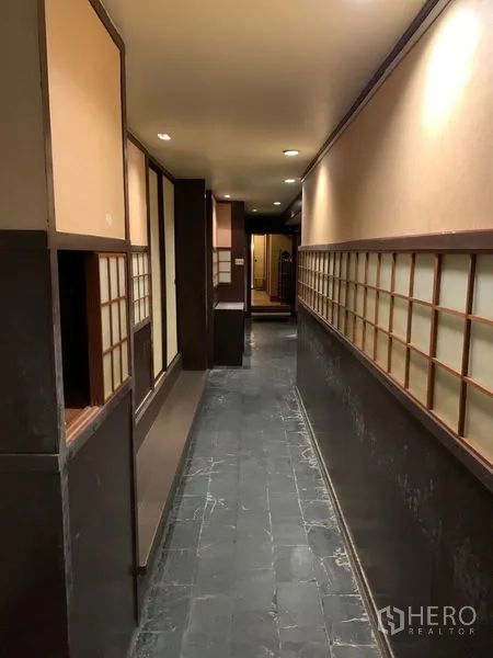 零售空间 出租在Bang Rak, Bangkok - 长走道，石质地面与障子风墙面，氛围照明。