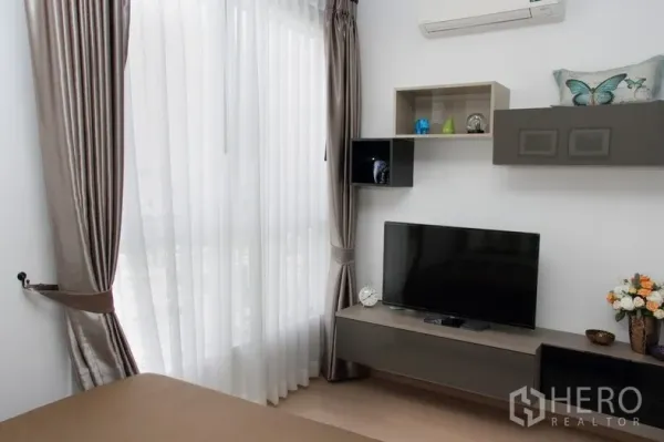 คอนโด ให้เช่าหรือขายในWatthana, Bangkok - มุมห้องนอนพร้อมชั้นวางทีวี ตู้แขวน และผ้าม่านสูงเต็มบาน