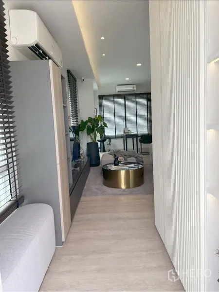 Detached House for rent or sale in Prawet, Bangkok - Hallway leading to the living space with full-height windows and plants.