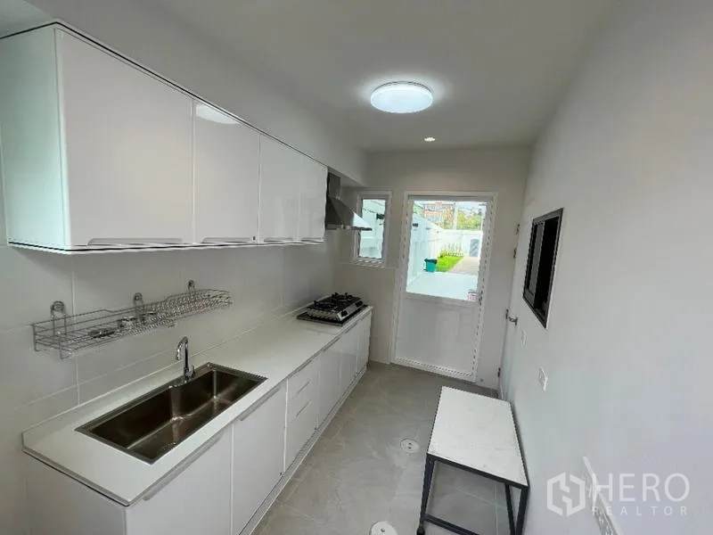 独立式住宅 出租在Phaya Thai, Bangkok - 独立泰式厨房，燃气灶、水槽与后门。