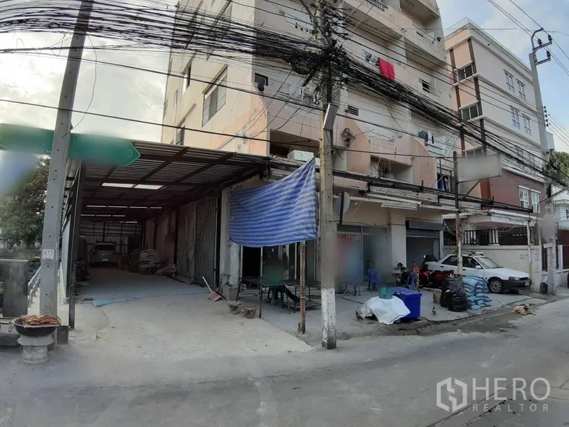 Warehouse for rent in Chatuchak, Bangkok - Street‑front warehouse entrance with covered loading driveway and metal gates in Chatuchak.