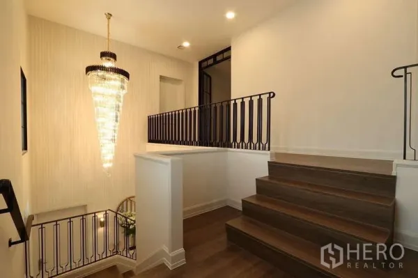 บ้าน ให้เช่าในSaphan Sung, Bangkok - โถงบันไดราวเหล็กสีดำพร้อมโคมระย้าคริสตัลสวยโดดเด่น