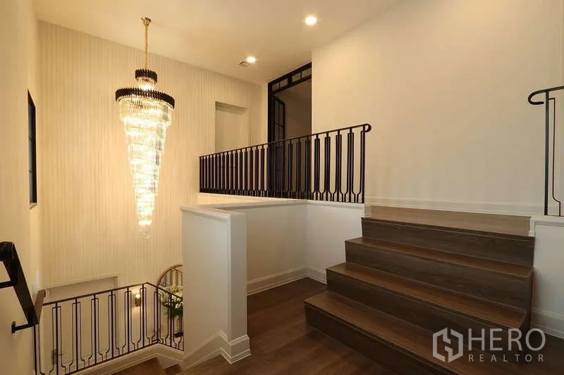 บ้าน ให้เช่าในSaphan Sung, Bangkok - โถงบันไดราวเหล็กสีดำพร้อมโคมระย้าคริสตัลสวยโดดเด่น