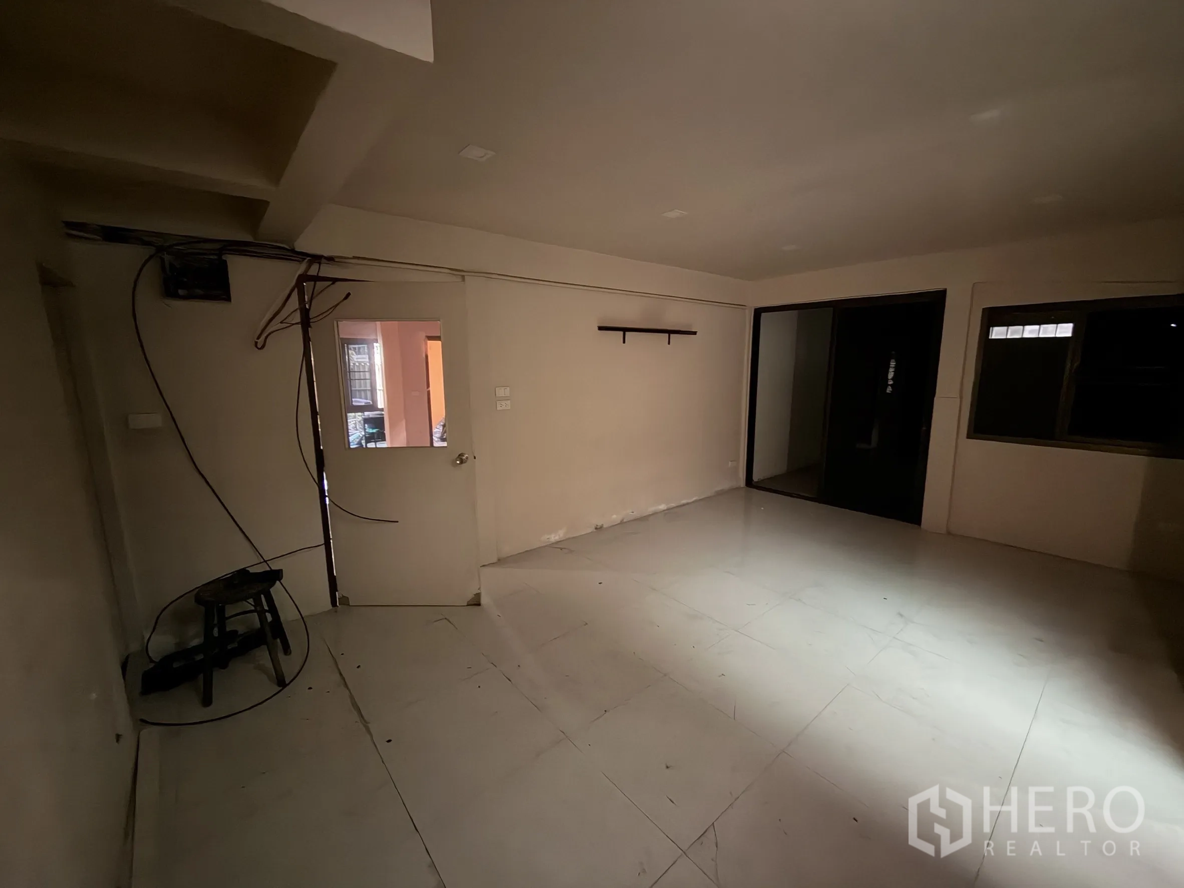 Shophouse for rent in Sathon, Bangkok - Multipurpose room with white tile floor, sliding glass door and exposed cables.