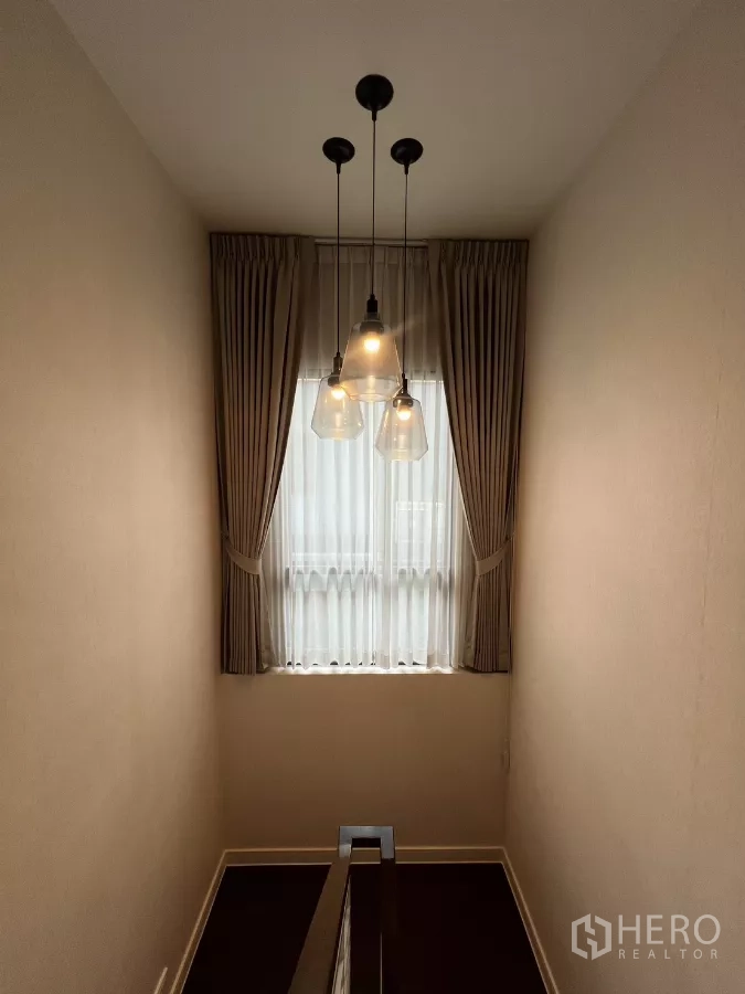 บ้าน ให้เช่าในBang Kapi, Bangkok - โถงบันไดมีโคมไฟแขวน และหน้าต่างสูงติดผ้าม่าน