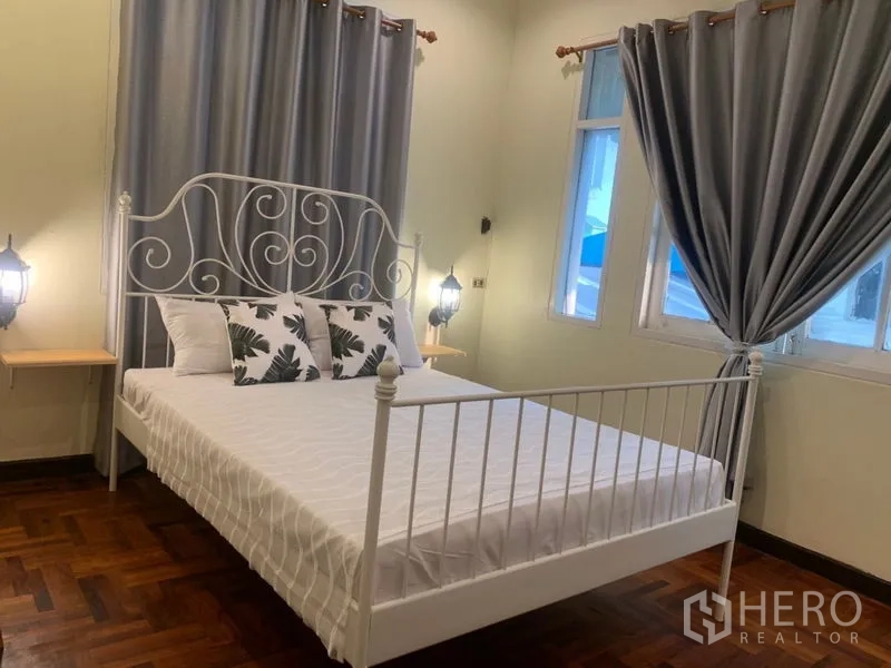 Home Office for rent in Suan Luang, Bangkok - Bedroom with decorative white metal bedframe and grey curtains.