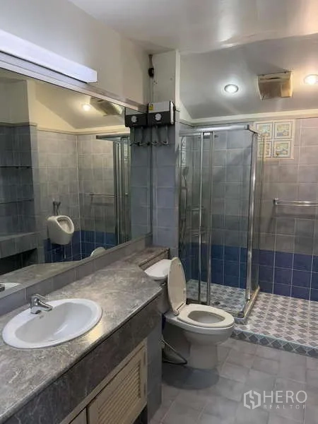 Detached House for rent in Bang Kapi, Bangkok - Bathroom with long vanity, toilet and glass‑enclosed shower area.